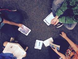 students holding iPads and collaborating