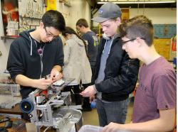 SETH GORDON - Joe Murphy, Alexander Berger and Kyle Hatch tinker with their robot at Newberg High School last week. The trio are part of the Iron Men Mark2 team, which itself is one of four NHS robotics teams that will compete at super qualifying tournaments this weekend in hopes of advancing to the First Tech Challenge state meet.