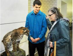SETH GORDON - Newberg High School student Tristan Tuttle? shows off his senior project to a visitor at TigerCon April 22. Tuttle spent more than 40 hours constructing his taxidermied cat. 