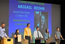 [SETH GORDON - (From left to right) Jacqueline Baca, Jay Byers, Ben Fox, Hayley Hensley and Jakob Holter take the stage June 1 at the NHS all-sports dessert as recipients of Newberg High School's 12-sport-athlete award, which recognizes seniors who have played a sport in each season for all four years of their career. Also receiving the honor were Chase Pothier, Caleb Rauch and Abby Reohr.]